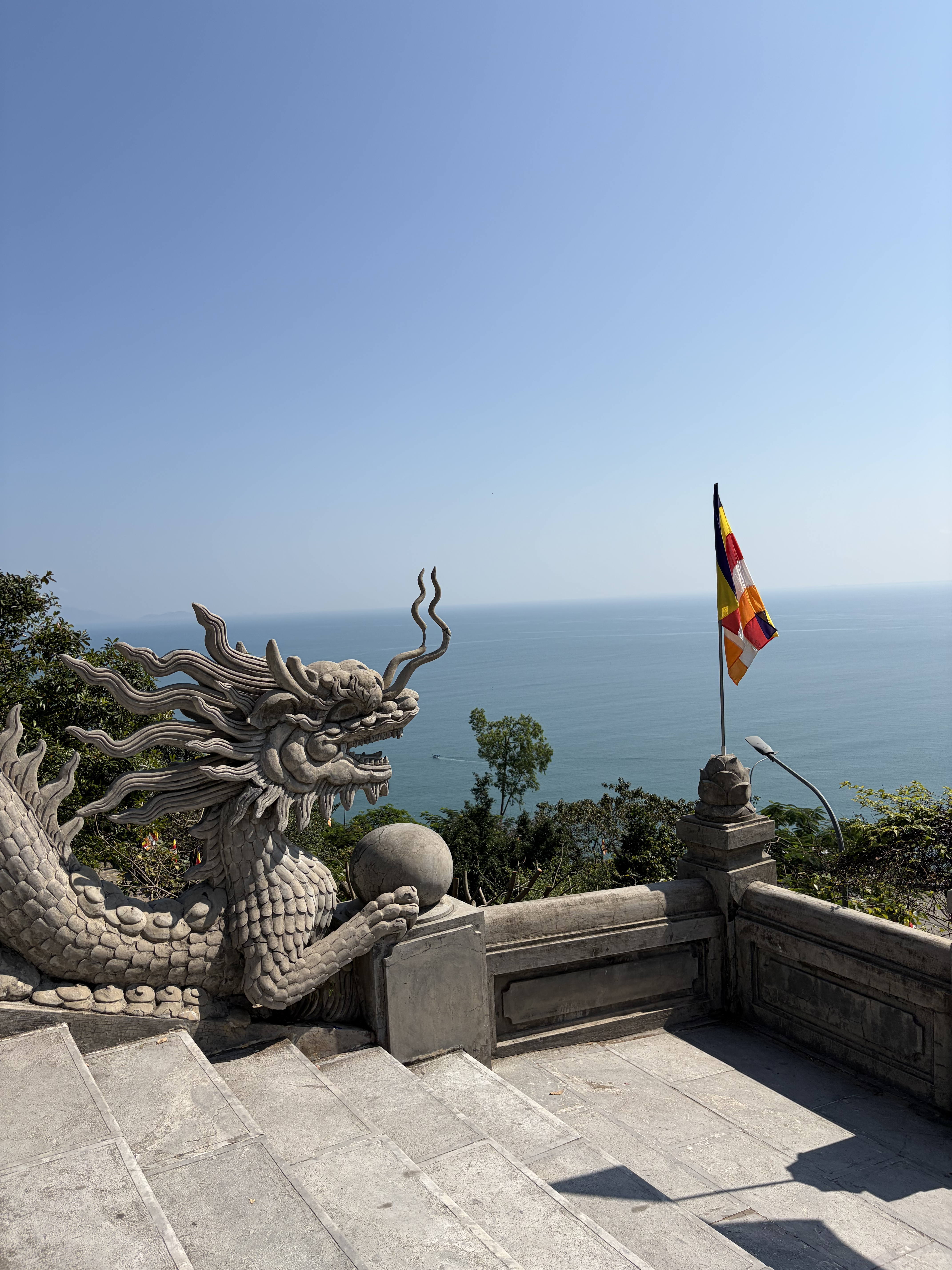 A stone dragon statue overlooking the sea at a hillside pagoda in Đà Nẵng
